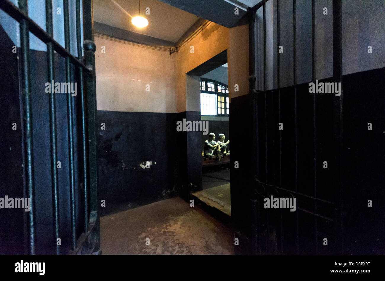 HANOI, Vietnam - A view through a corridor in Hoa Lo Prison. Through the iron gates can be seen plastic dummies illustrating the conditions that prisoners were kept in by the French colonial government. The prison is better known in the West as the Hanoi Hilton, the place that American pilots were kept as POWs during the Vietnam War. Stock Photo