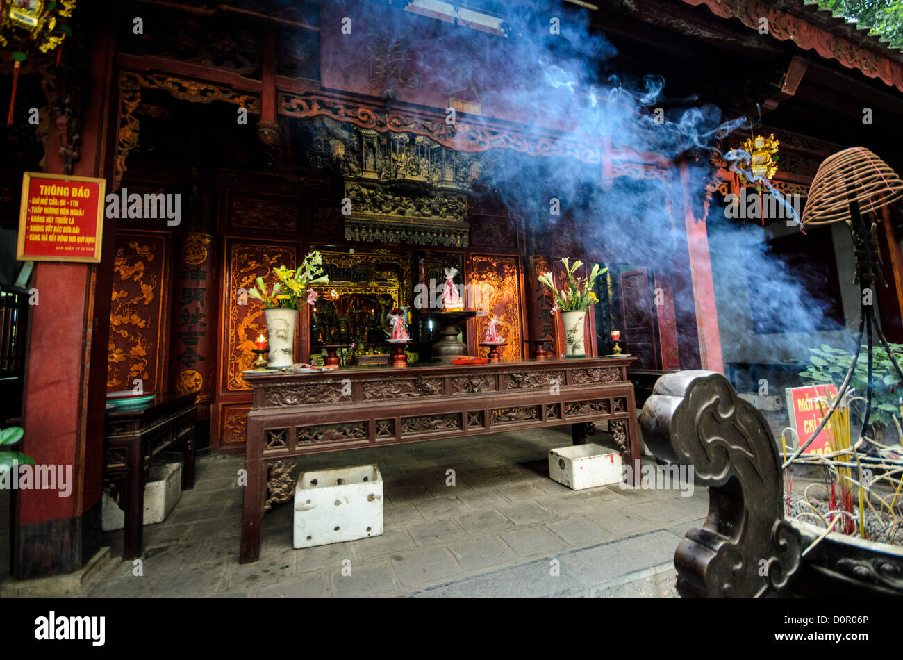 HANOI, Vietnam - Blue smoke from the burning incense wafts through the air outside Quan Thanh Temple in Hanoi. The Taoist temple dates back to the 11th century and is located close to West Lake. Stock Photo