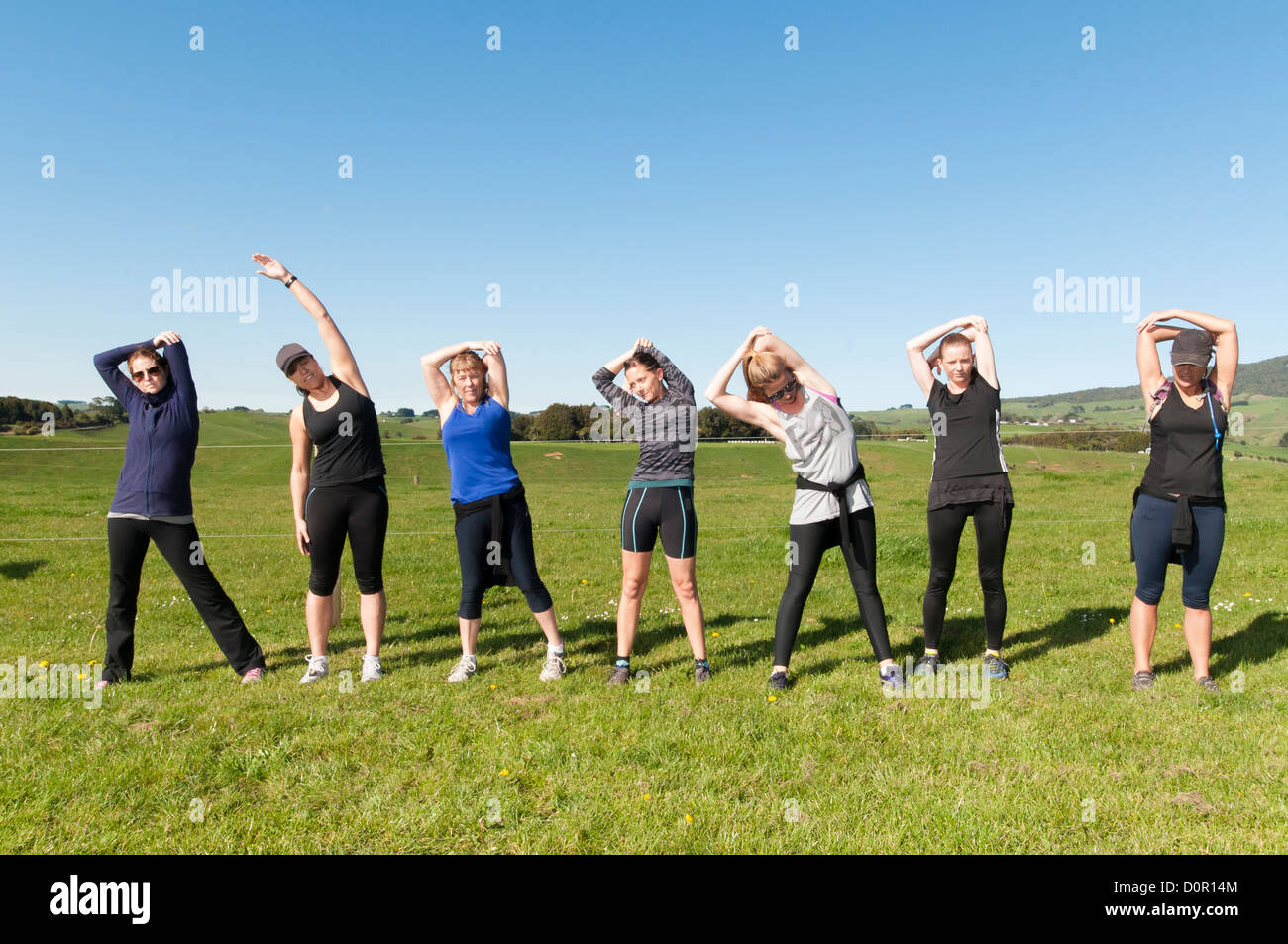 Women stretching before going on a cross country run through farmland and country side. Stock Photo