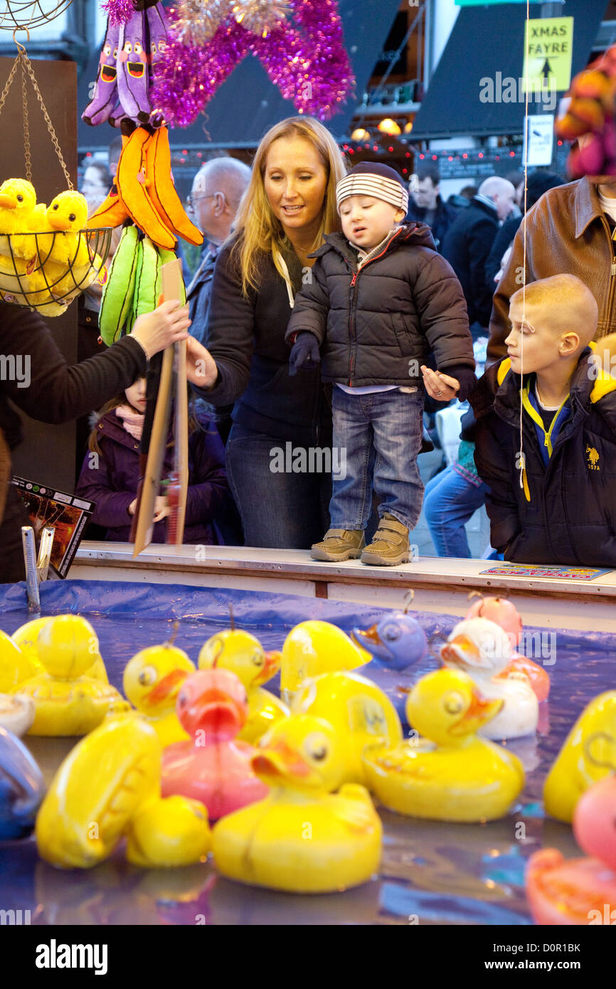 A family playing a fairground game of hook a duck, Bury St edmunds christmas fair fayre, Suffolk