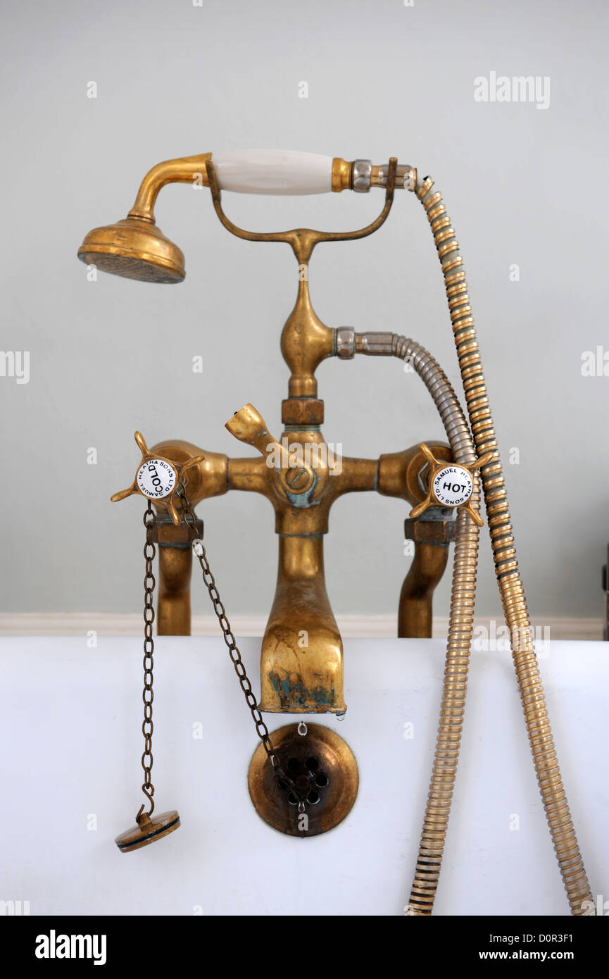 An antique brass mixer tap and shower head on a bath UK Stock Photo - Alamy