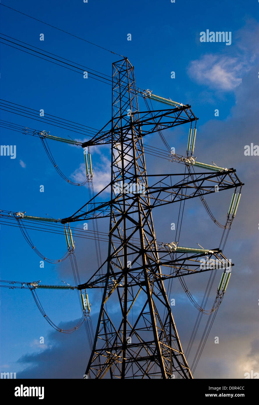 An electricity pylon against a blue cloudy sky Stock Photo - Alamy