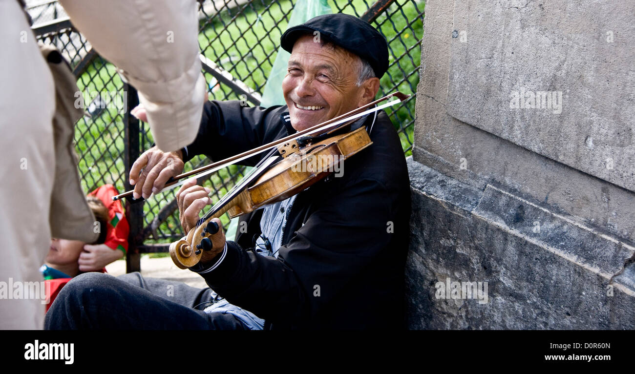 Smiling elderly violin busker accepting money Sacre Coeur Paris France Europe Stock Photo