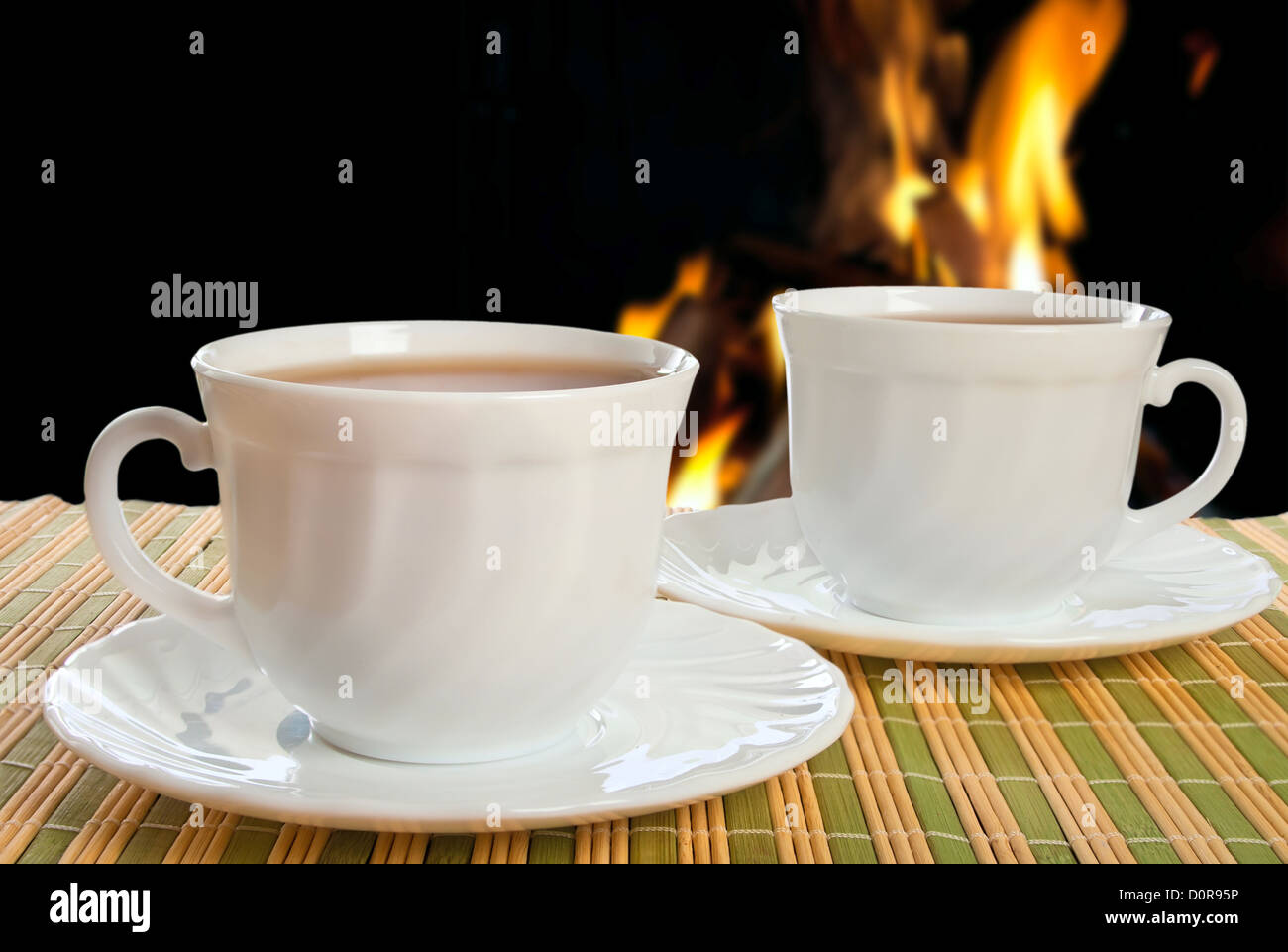 Two teacups on fire background. Stock Photo