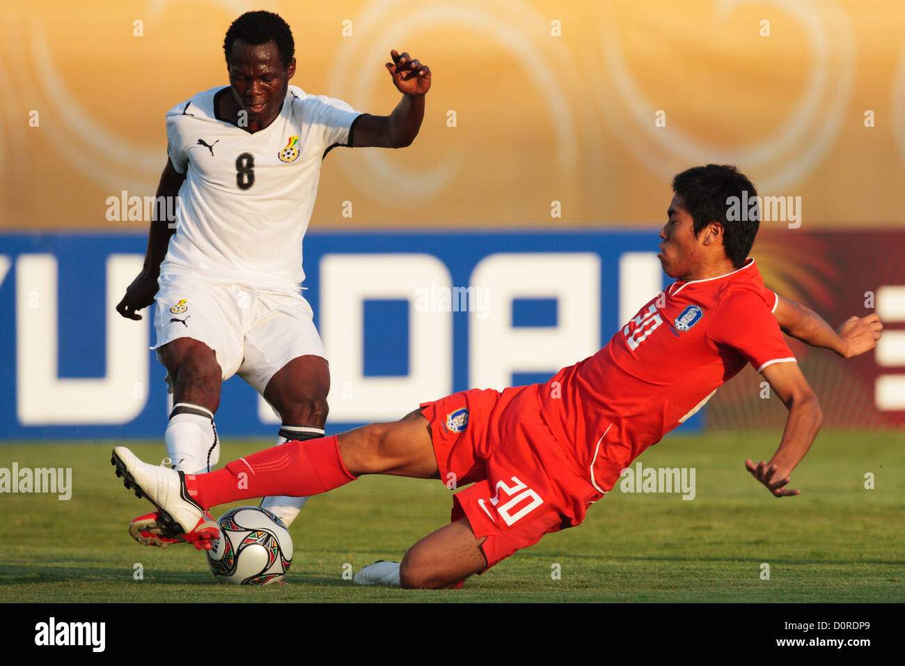 Hee Seong Park of South Korea (20) slides for a tackle on Emmanuel Agyemang Badu of Ghana (8) during a FIFA U20 World Cup match. Stock Photo