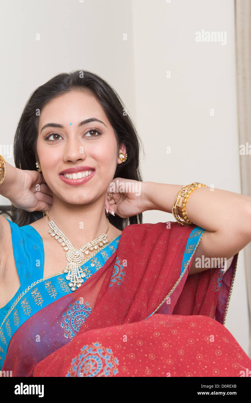 Woman putting on a necklace Stock Photo