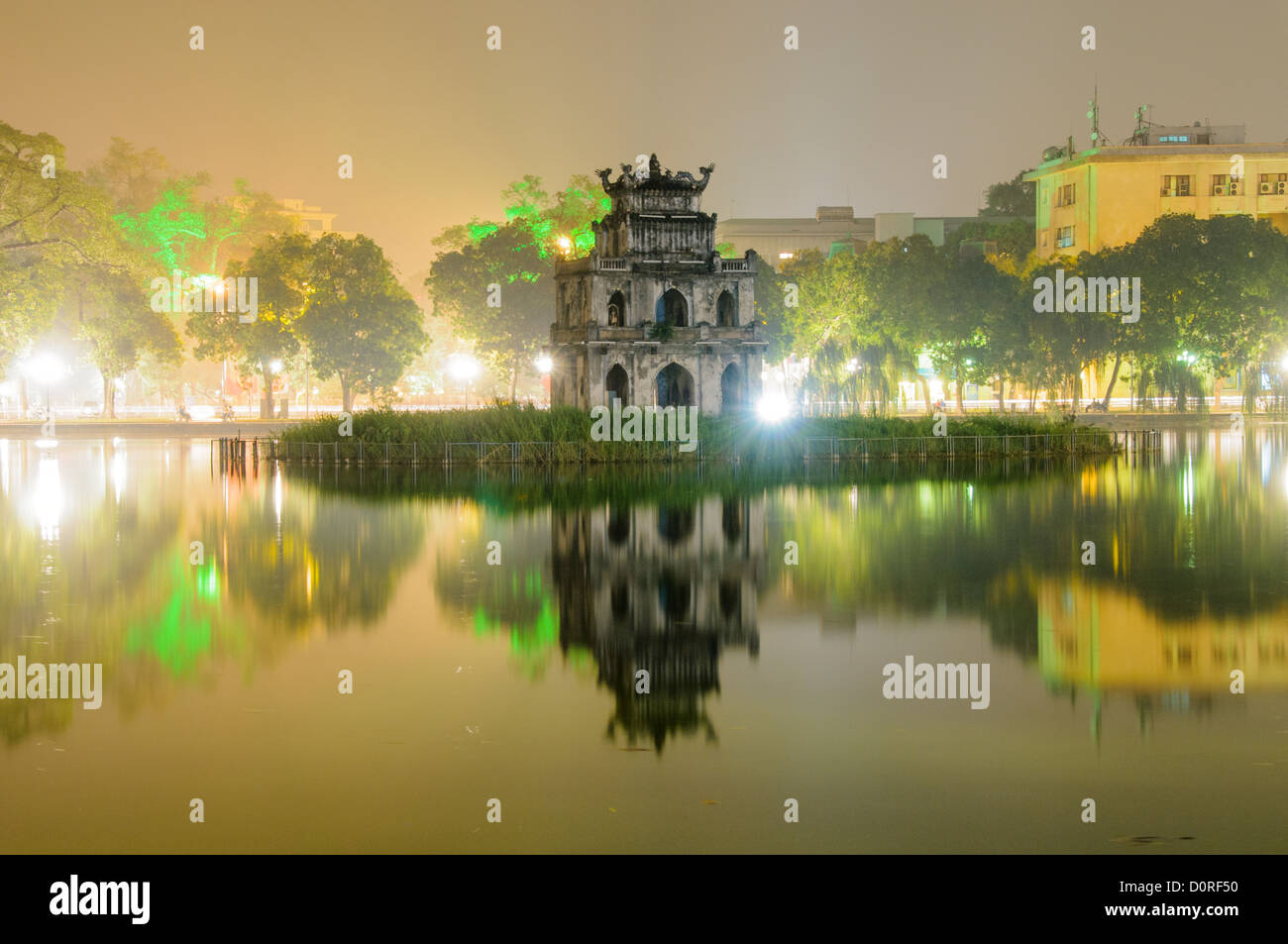 HANOI, Vietnam - Turtle Tower (Thap Rua) is reflected on the still waters of Hoan Kiem Lake on a foggy Hanoi night. Stock Photo