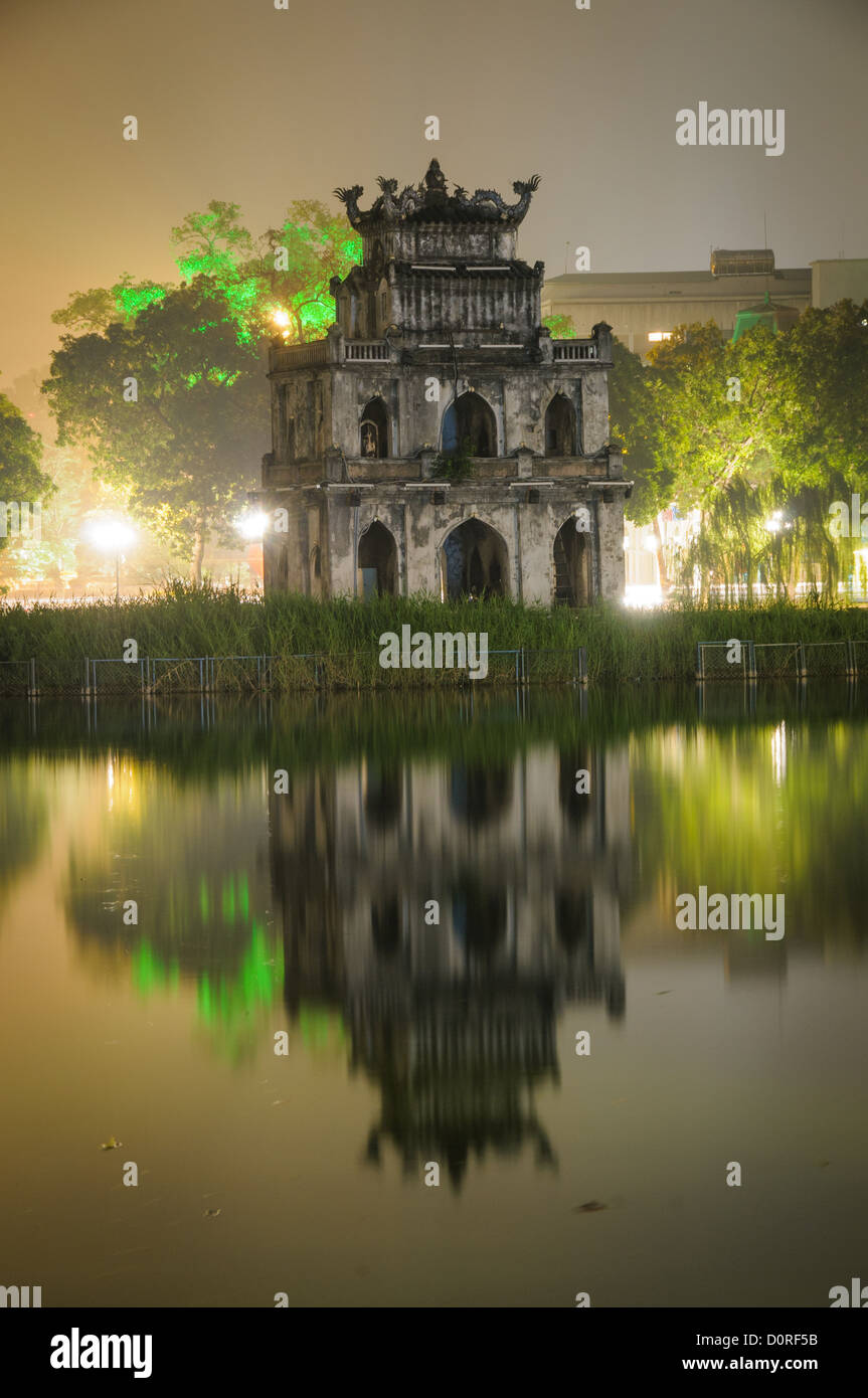 HANOI, Vietnam - Turtle Tower (Thap Rua) is reflected on the still waters of Hoan Kiem Lake on a foggy Hanoi night. Stock Photo