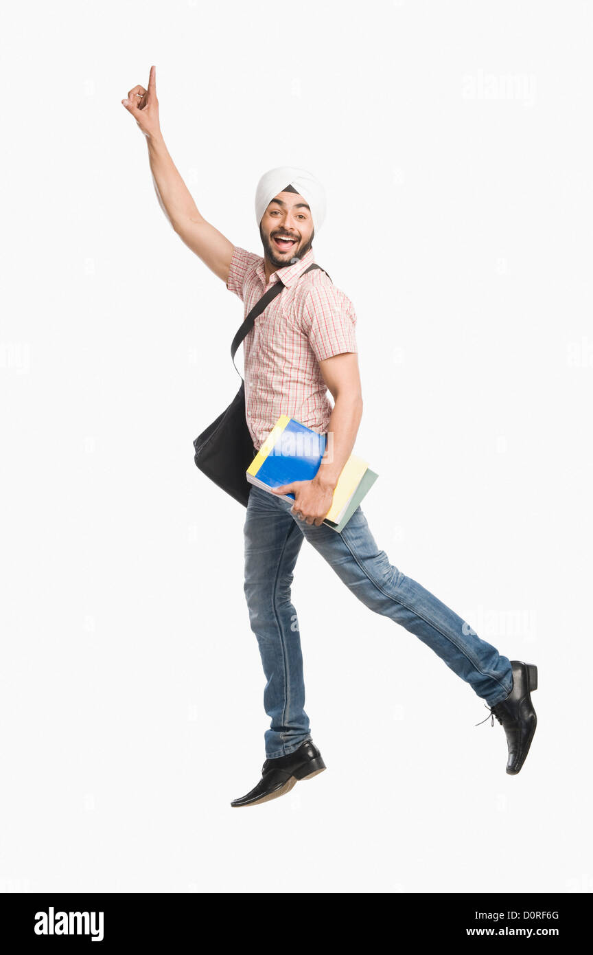 University student holding a book and smiling Stock Photo - Alamy