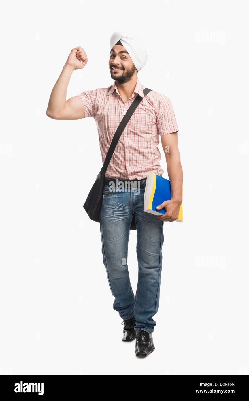University student holding a book and smiling Stock Photo - Alamy
