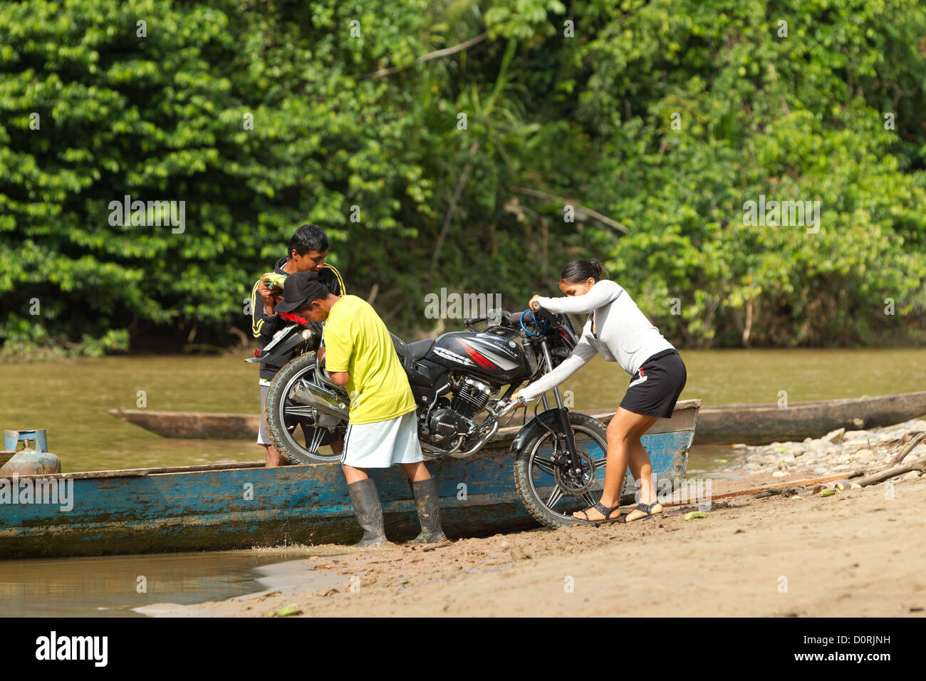 A Motorcycle Is Transported By Canoe To The Other Side Of The Napo River Stock Photo