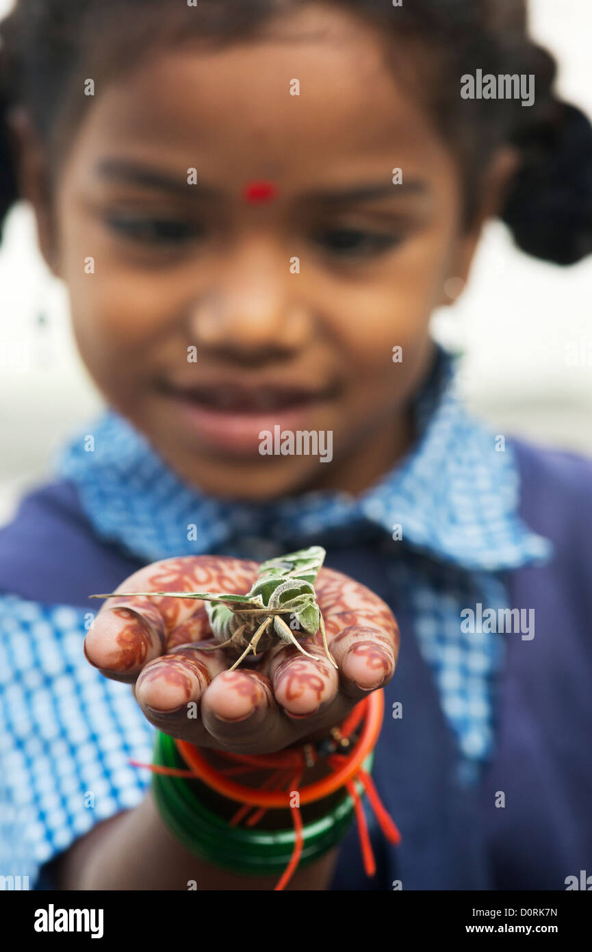 Young Indian school girl holding an Oleander Hawk moth . Daphnis nerii Stock Photo