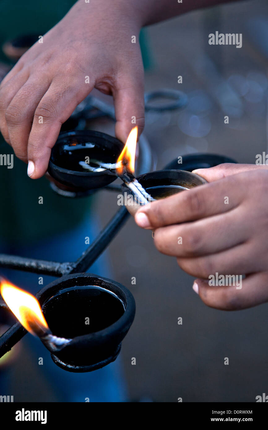 Devout lighting an oil lamp. Temple of the Sacred Tooth Relic. Kandy. Sri Lanka Stock Photo