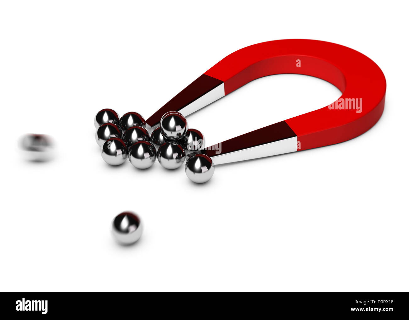 red horseshoe magnet attracting some chrome balls, white background Stock Photo
