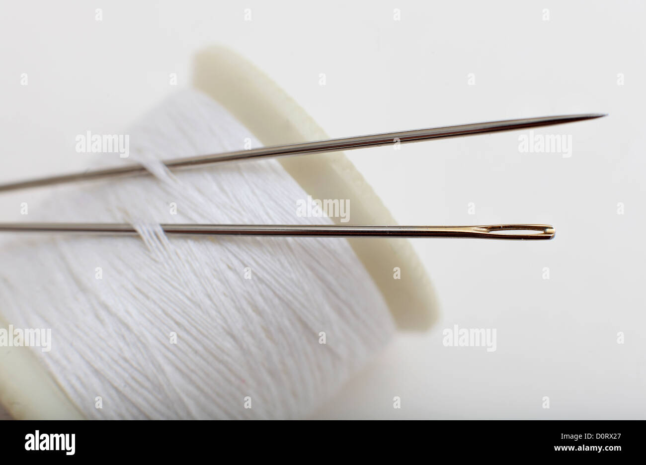 A Cotton reel with neddles used for sewing, Needlework and embroidery. Stock Photo