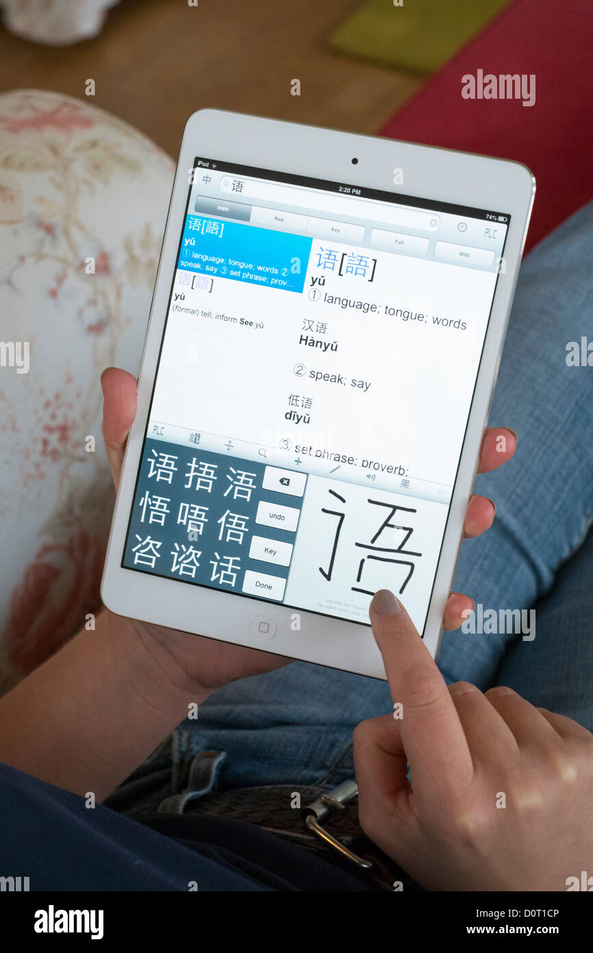 Student using iPad mini to learn Mandarin Chinese foreign language using educational application Stock Photo