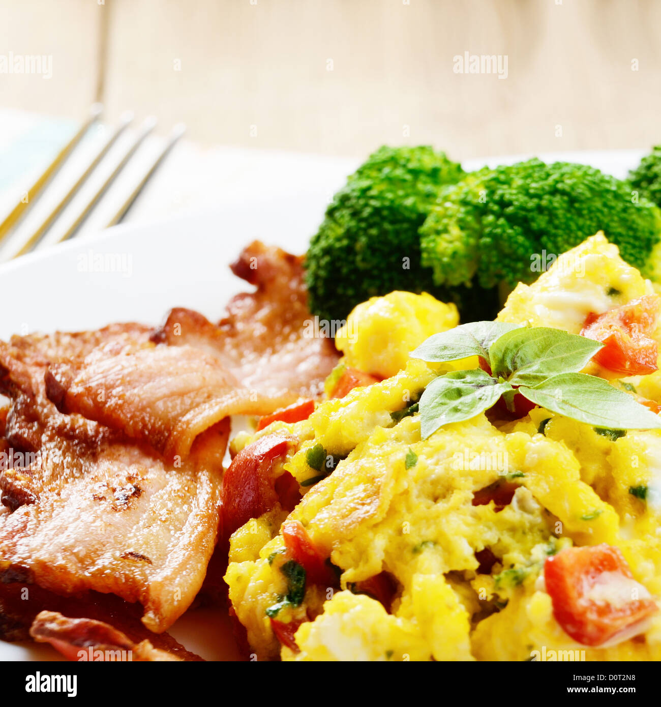 Scrambled eggs with fried bacon on the white plate Stock Photo - Alamy