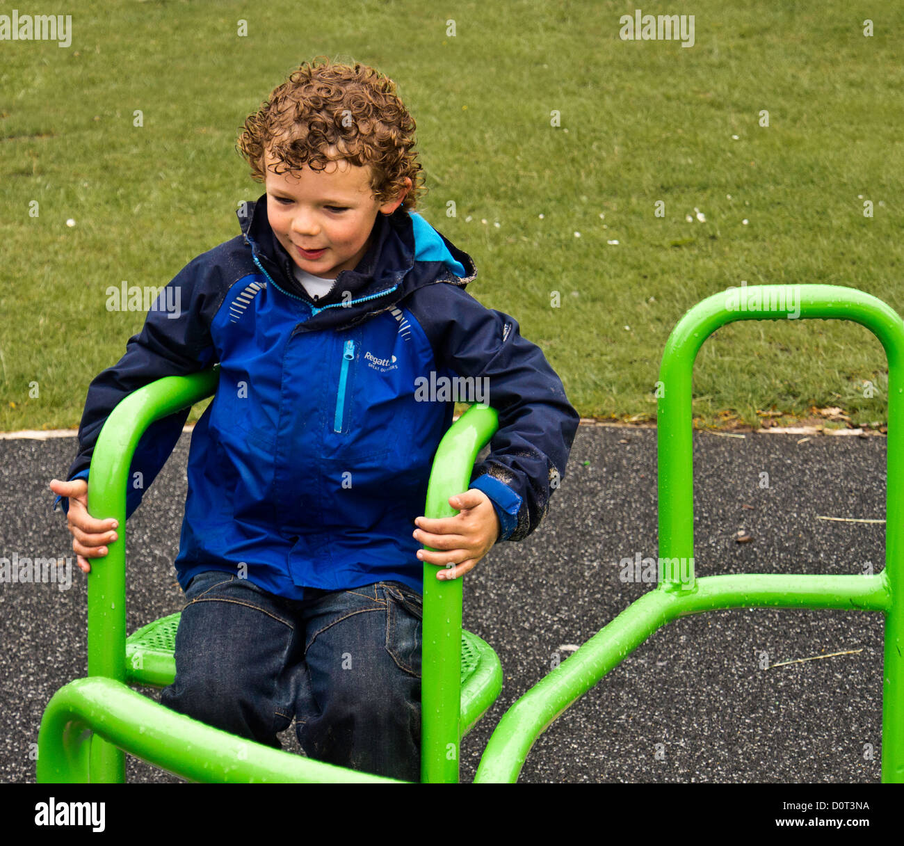 Young boy enjoying roundabout ride at Worden park, Leyland wearing