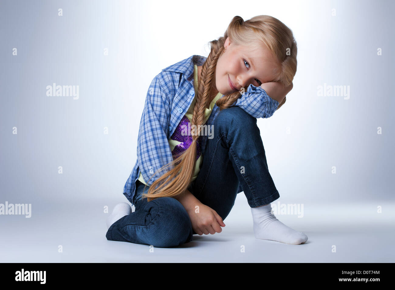Happy girl sitting on floor Stock Photo - Alamy