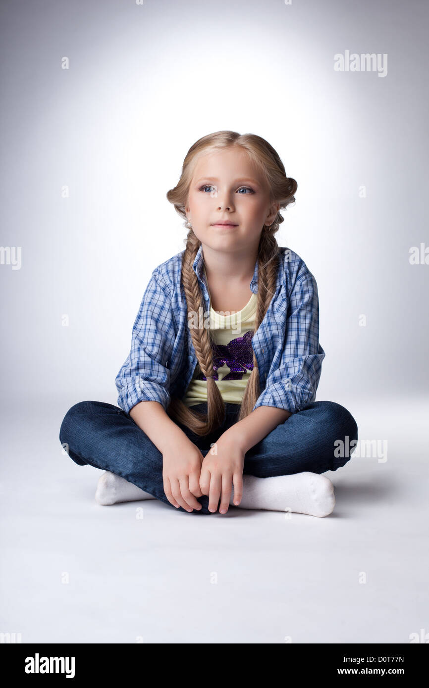 Pretty blonde girl sitting on floor Stock Photo - Alamy