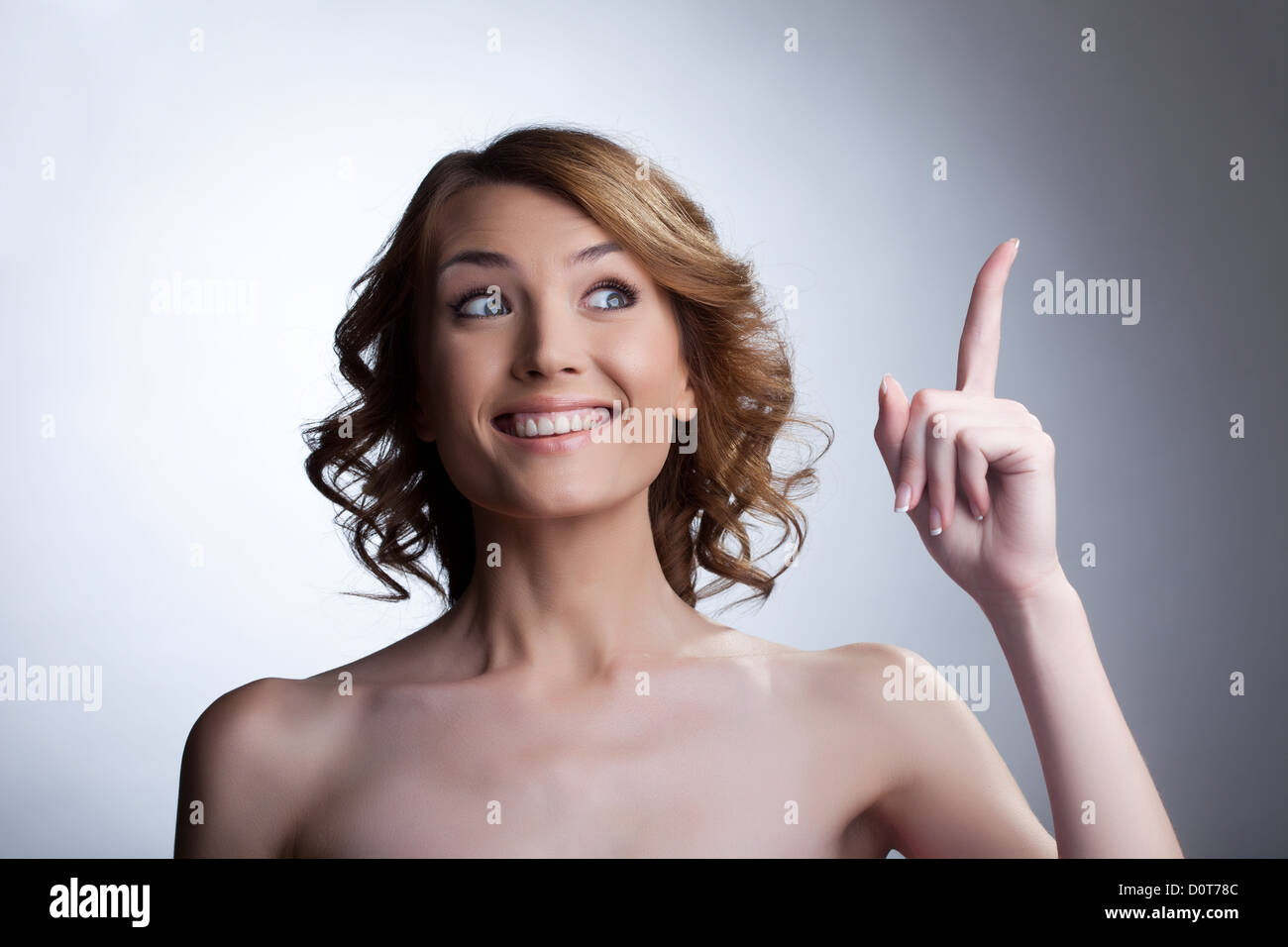 Pretty young woman point finger and smile Stock Photo - Alamy