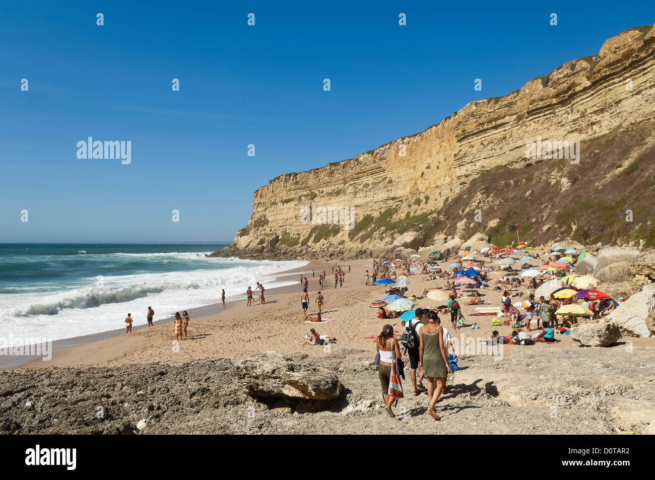 Bathers in the small beach of Foz, Sesimbra, Portugal Stock Photo