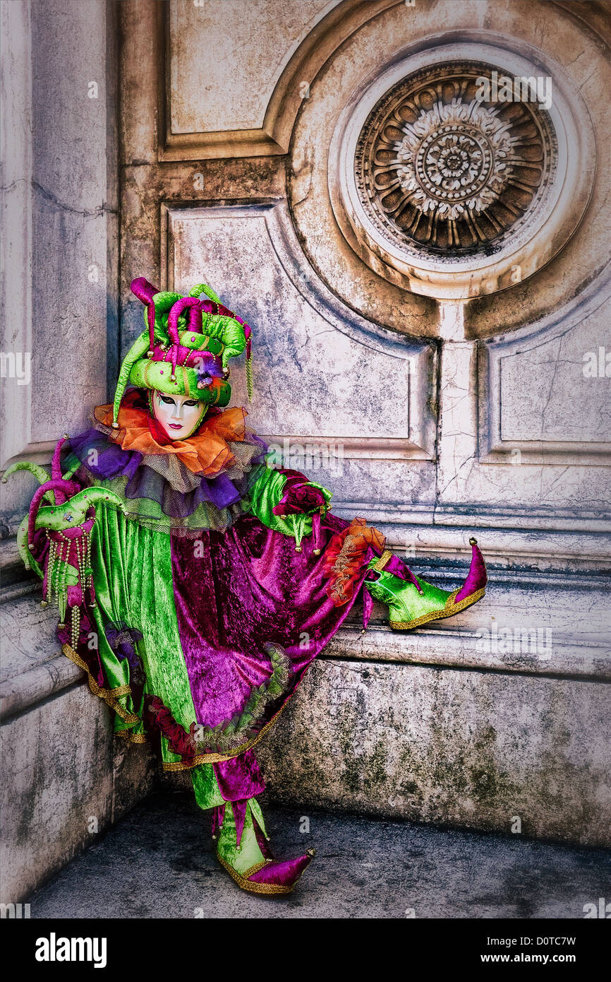 Masked participant dressed as a jester during Carnival in Venice, Italy in front of the Basilica di Santa Maria della Salute Stock Photo