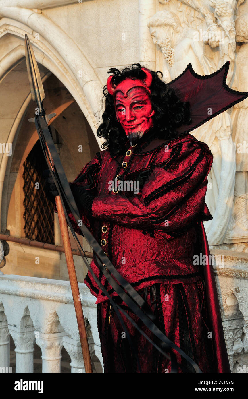 Masked devil standing in front of the Doge's Palace in Piazza San Marco during Carnival in Venice, Italy Stock Photo