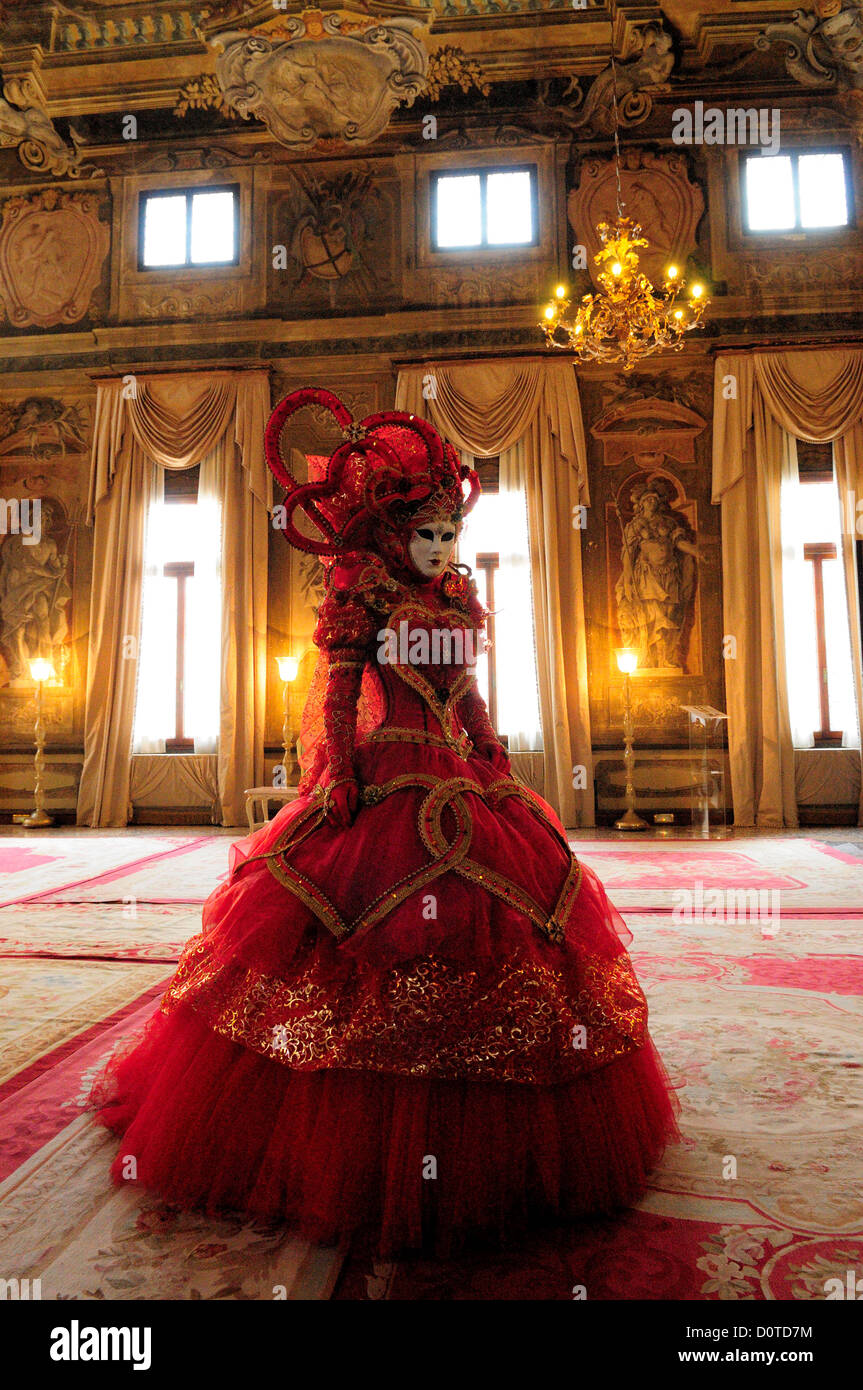 Masked participant standing in the ballroom of a centuries-old palace during Carnival in Venice, Italy Stock Photo