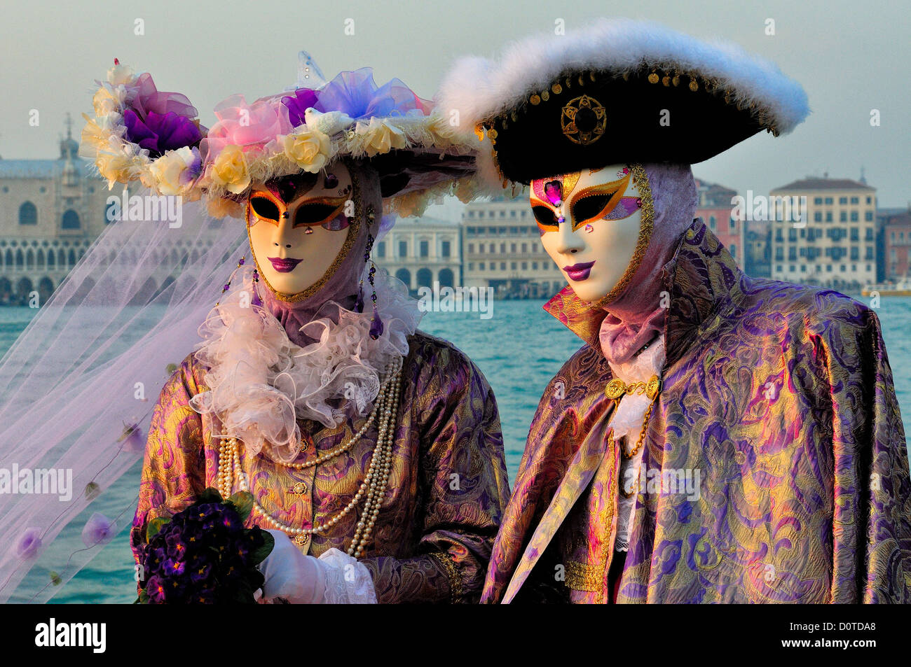 Masked participants overlook the Grand Canal in front of the Church of San Giorgio Maggiore in Venice during the annual Carnival Stock Photo