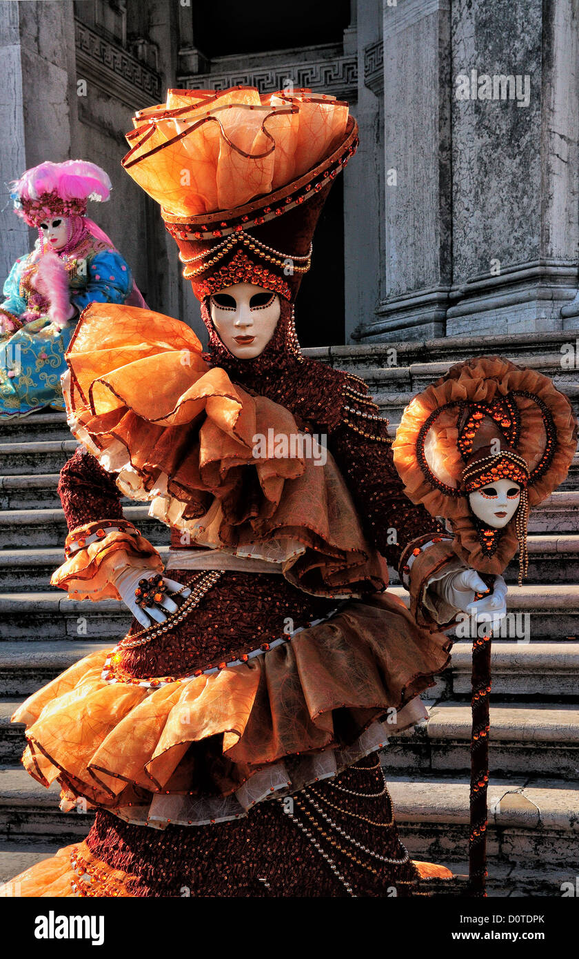 Masked woman on the steps of the Basilica di Santa Maria della Salute during Carnival in Venice, Italy Stock Photo