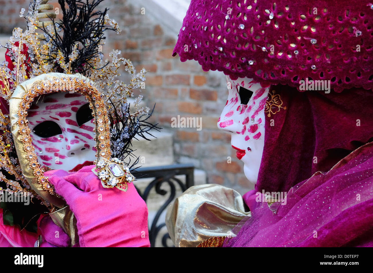 Masked participant at the Campo Santa Maria Formosa during Carnival in Venice, Italy with her face reflected in a mirror Stock Photo