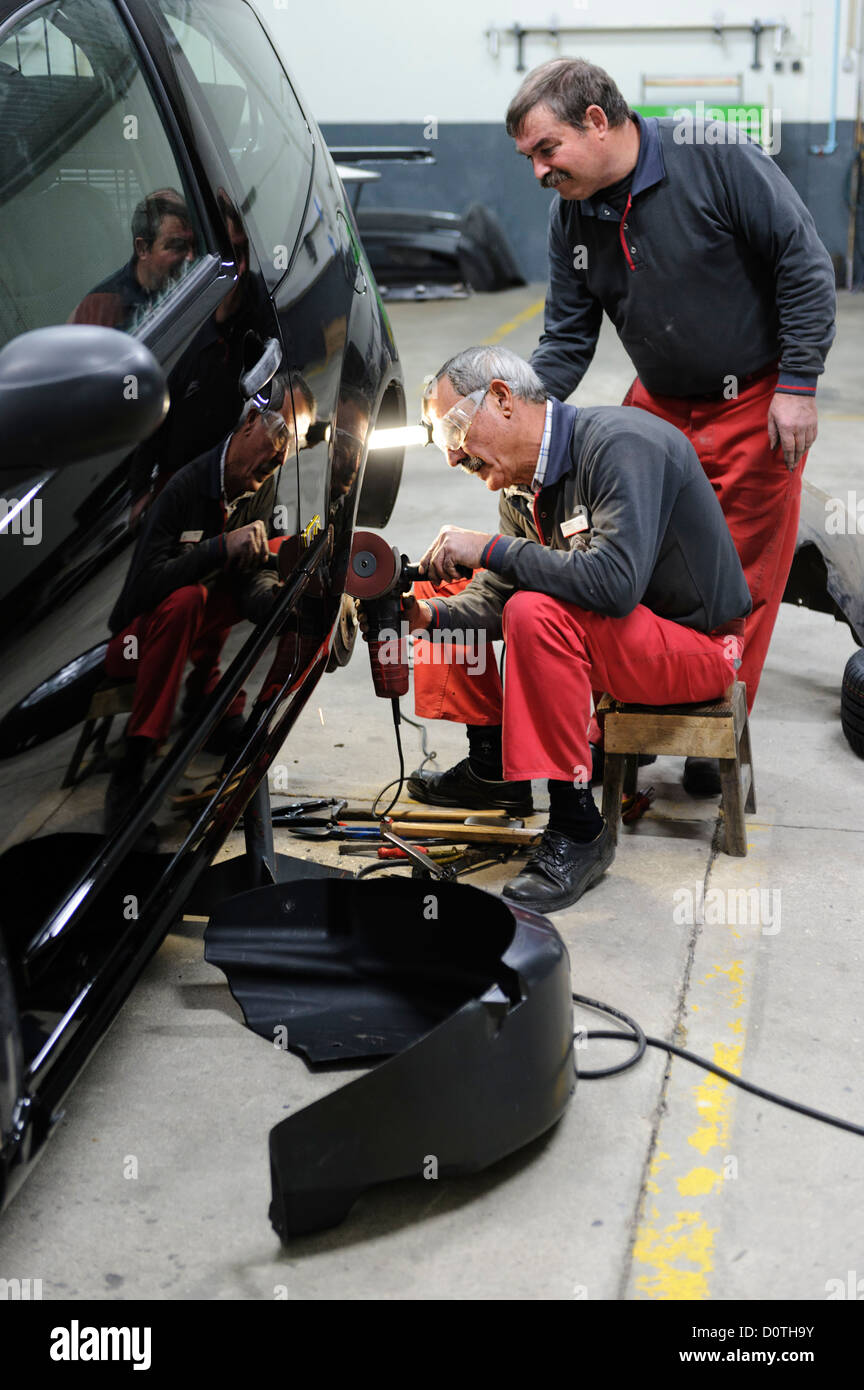 Two mechanics working in auto garage Stock Photo