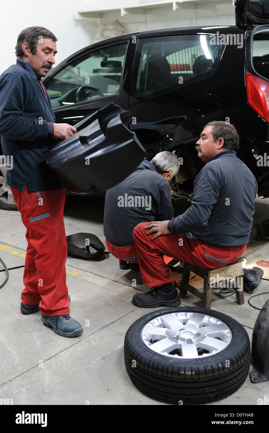 Three mechanics working in auto garage Stock Photo