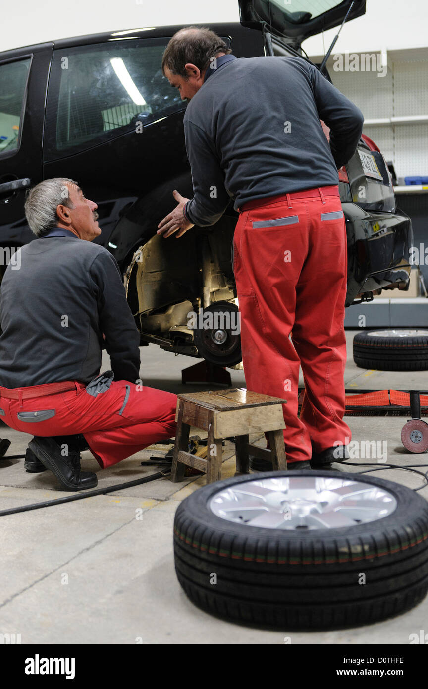 Mechanics changing car tyre in auto garage Stock Photo Alamy