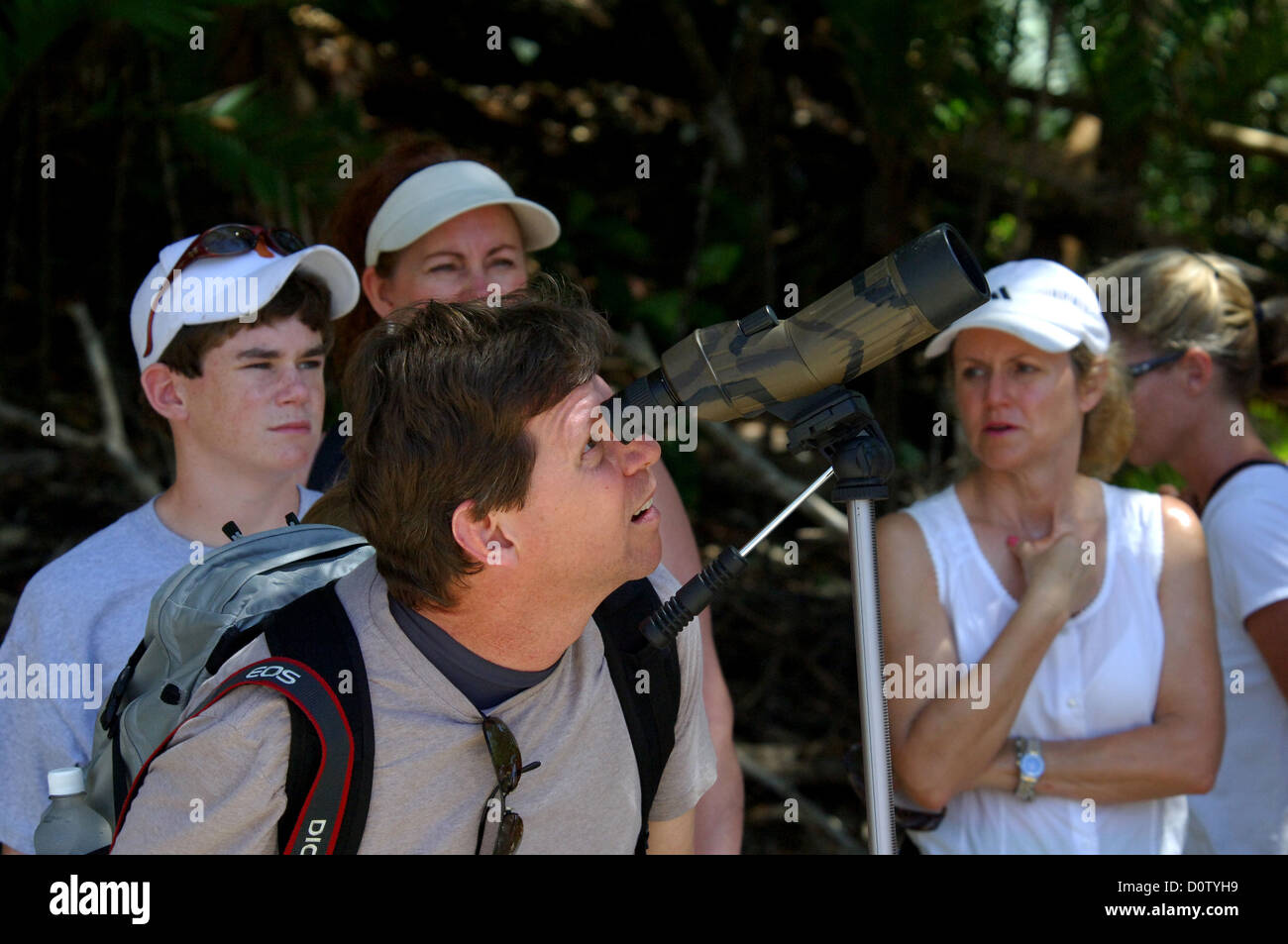 Tourists looking at birds and wildlife through a telescope at Manuel
