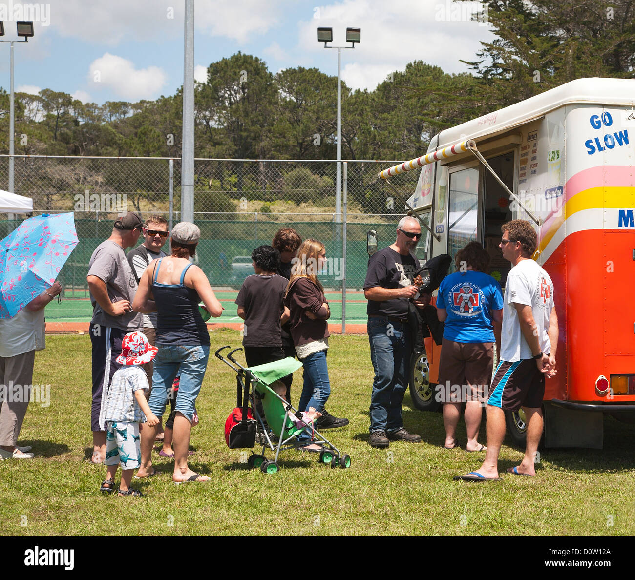 Families lining up to buy ice creams at an ice cream van. Mangawhai, Northland, North Island, New Zealand. Stock Photo