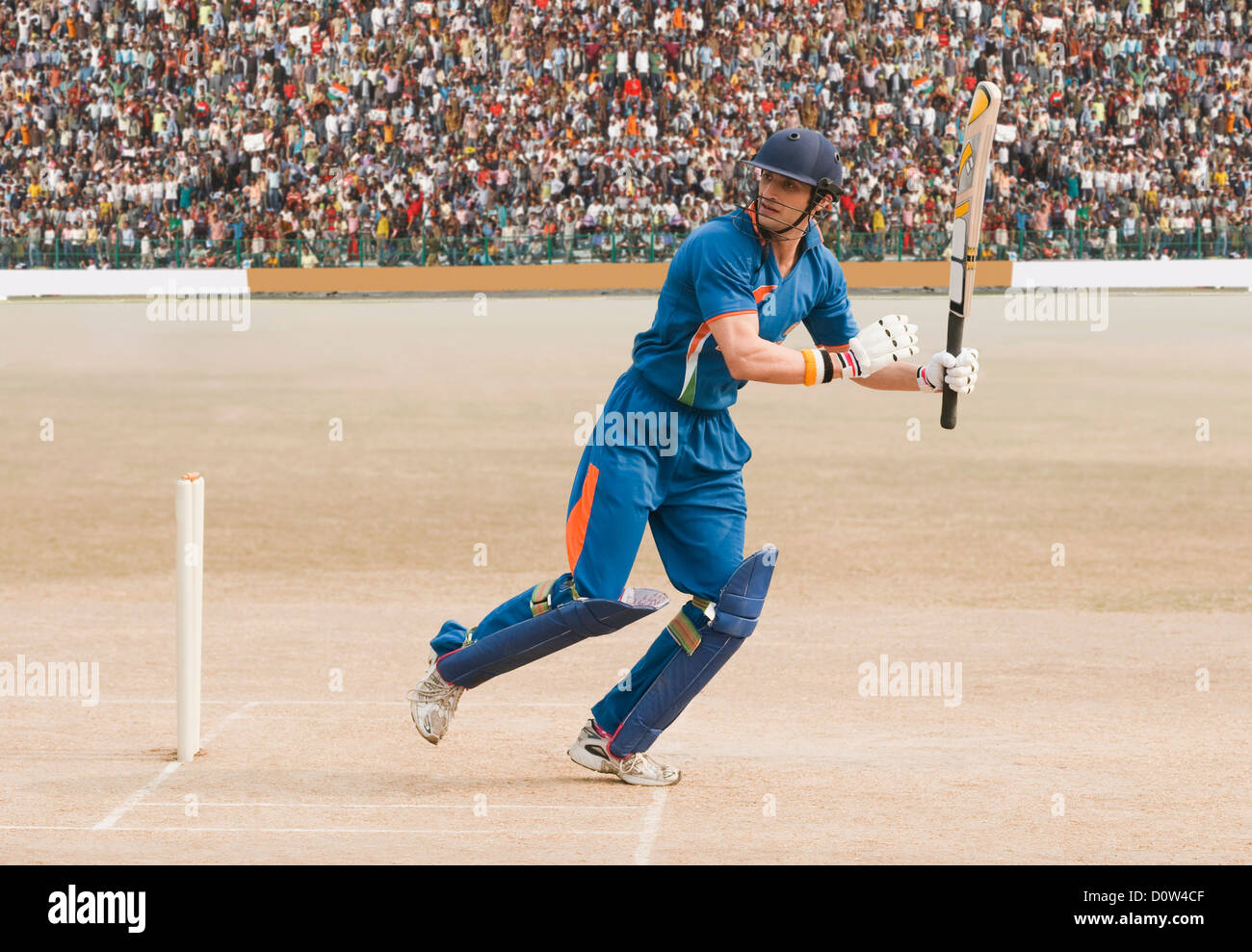 Cricket batsman in running position after playing a shot Stock Photo