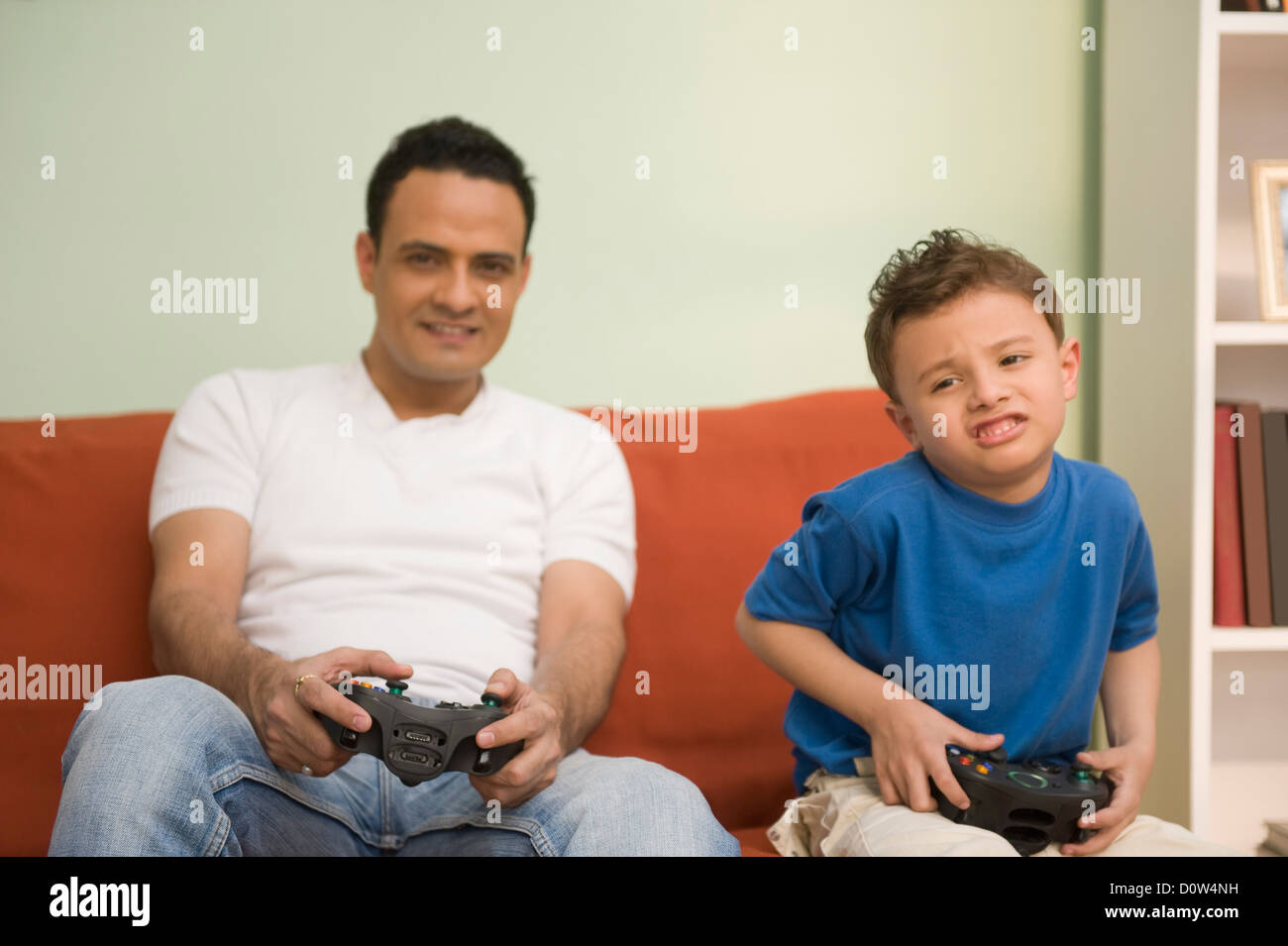 Man and his son playing a video game Stock Photo