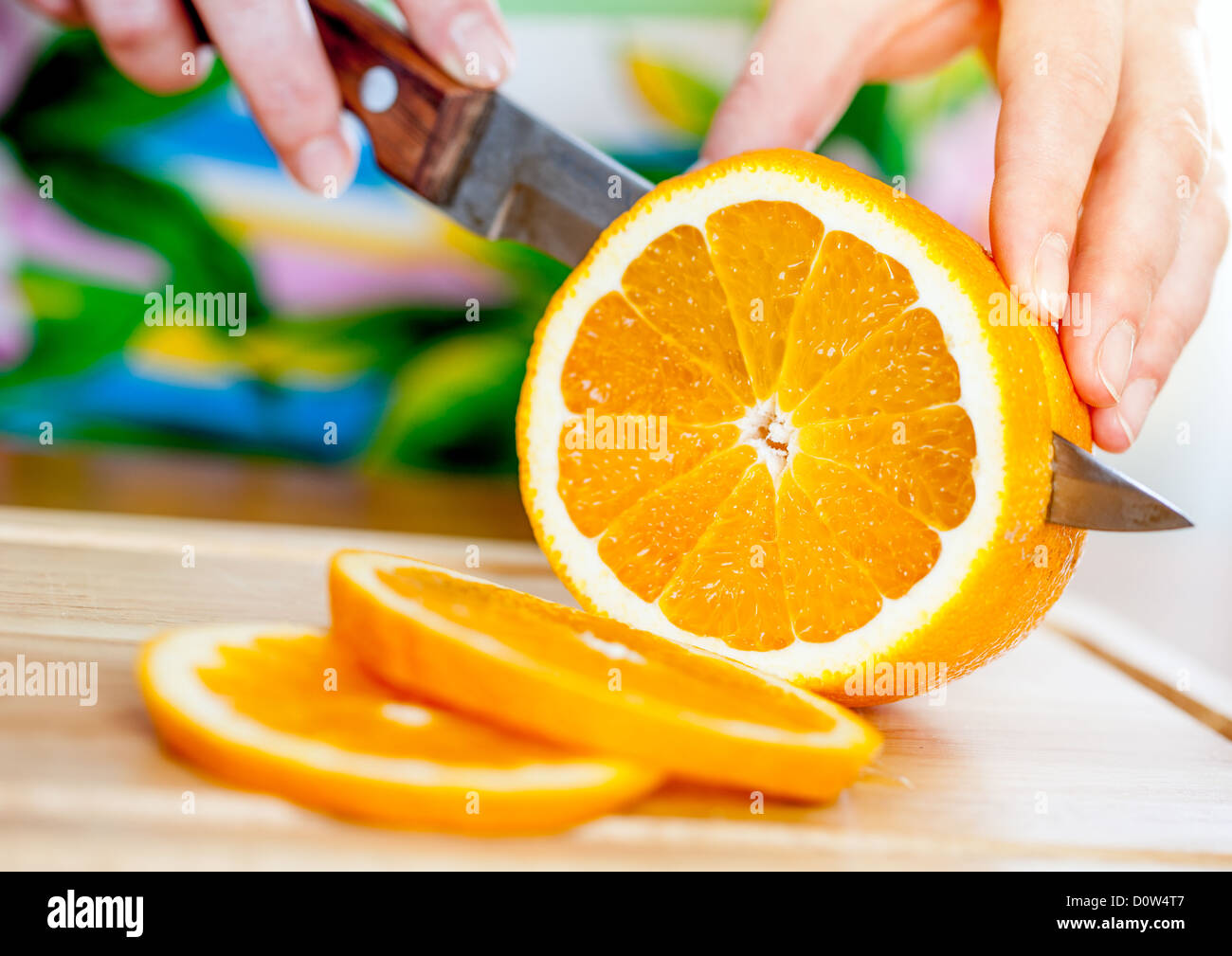 Woman's hands cutting orange Stock Photo