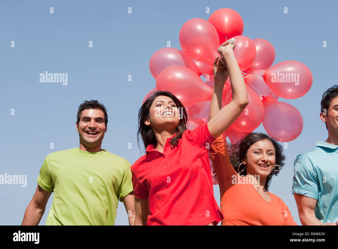 Friends holding balloons and enjoying Stock Photo - Alamy