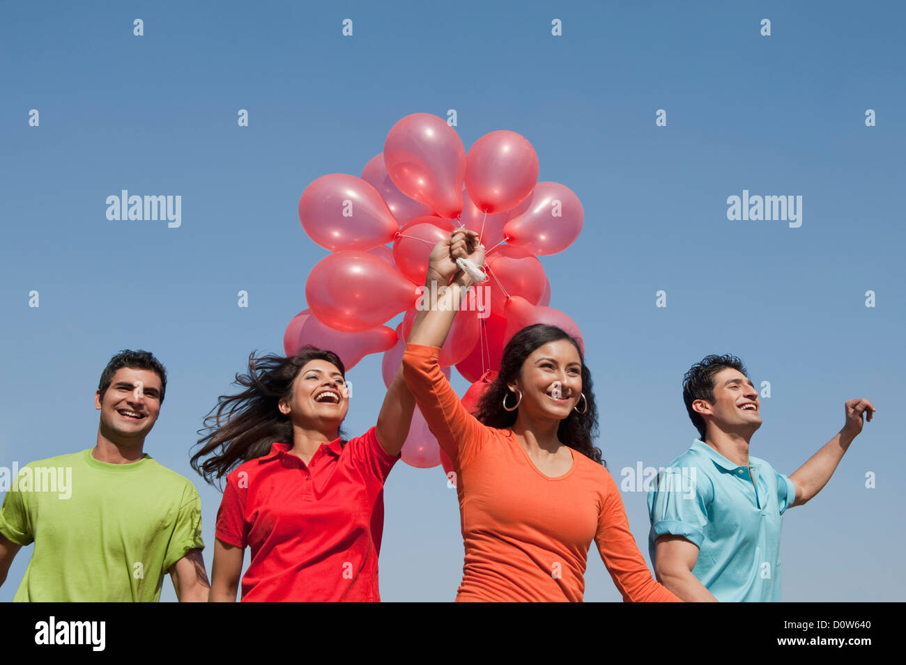 Friends holding balloons and enjoying Stock Photo - Alamy