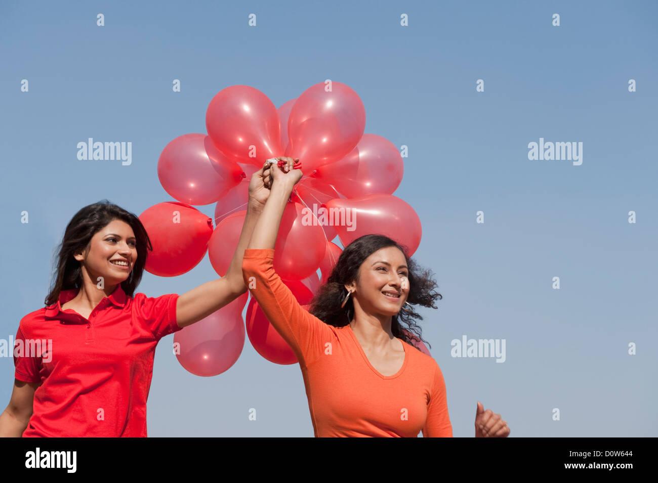 Friends holding balloons and enjoying Stock Photo - Alamy