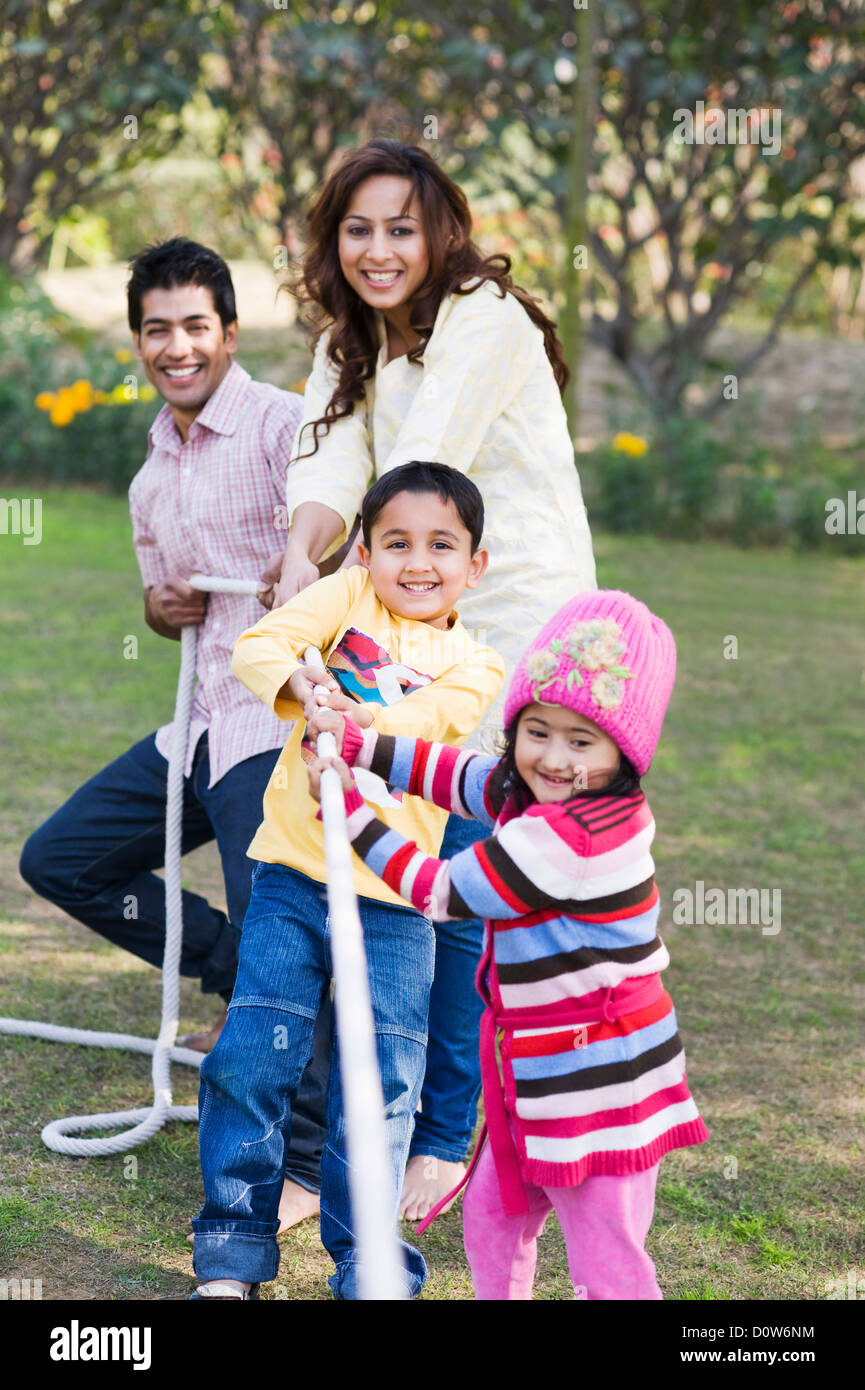 Family playing tug of war in a garden, Gurgaon, Haryana, India Stock Photo