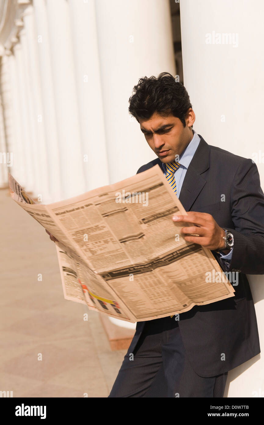 Businessman reading a newspaper, Gurgaon, Haryana, India Stock Photo