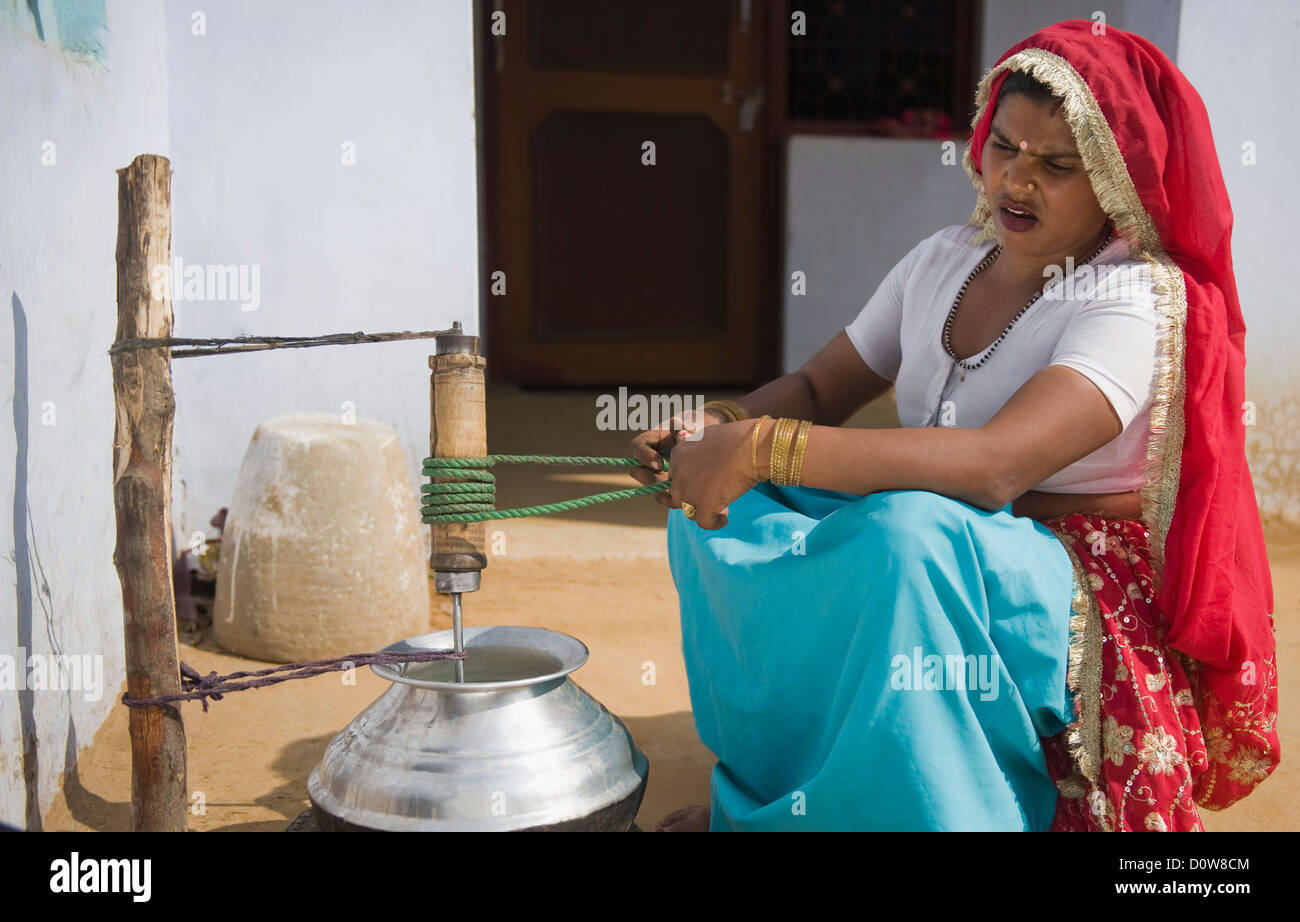 Woman churning butter, Farrukh Nagar, Gurgaon, Haryana, India Stock