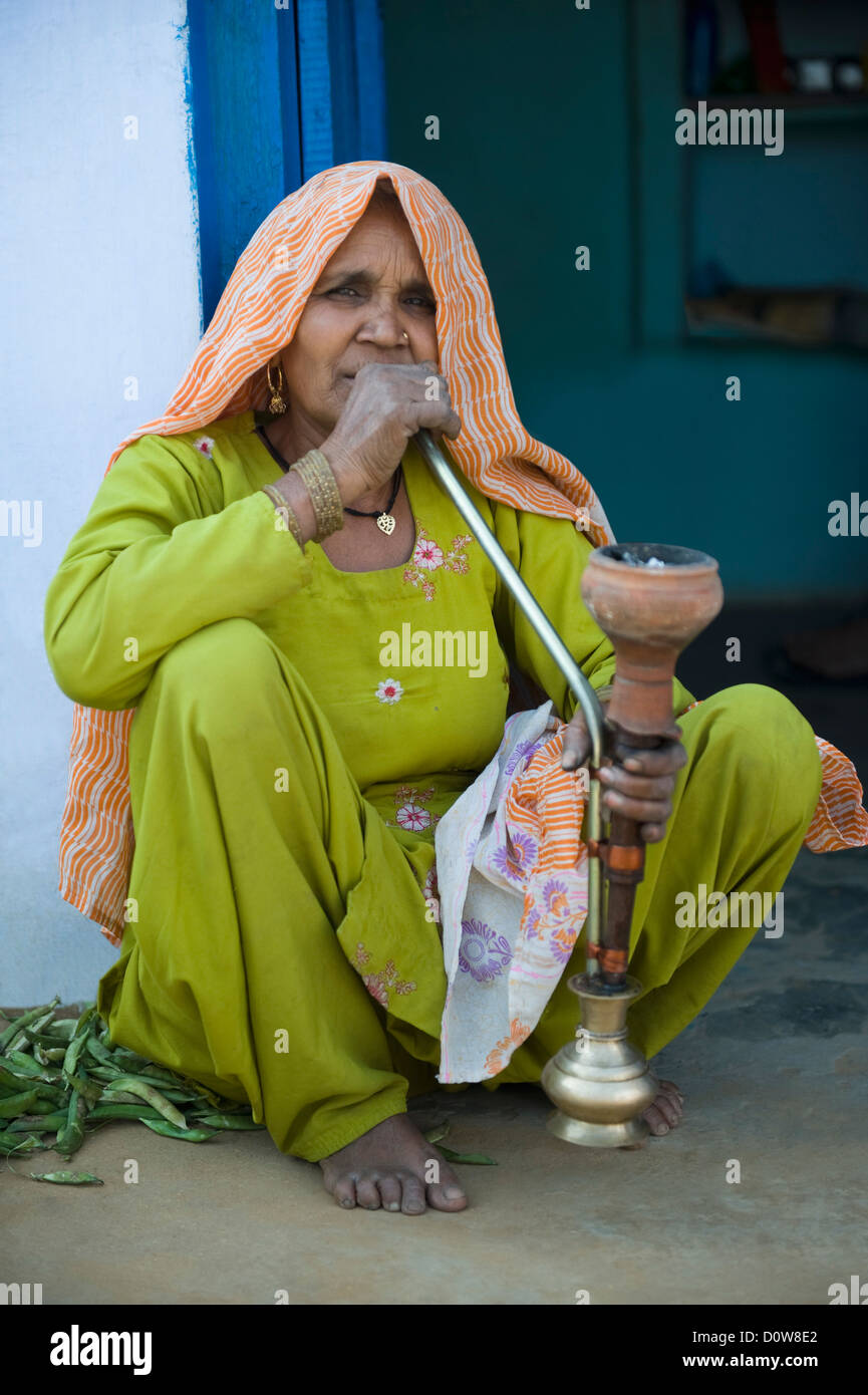 Woman smoking a hookah pipe, Farrukh Nagar, Gurgaon, Haryana, India