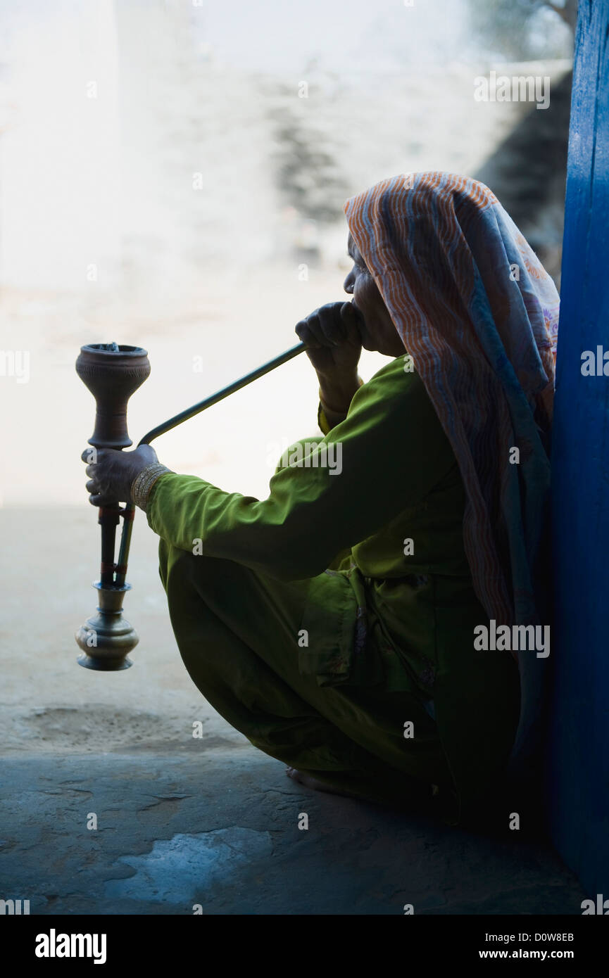 Woman smoking a hookah pipe, Farrukh Nagar, Gurgaon, Haryana, India