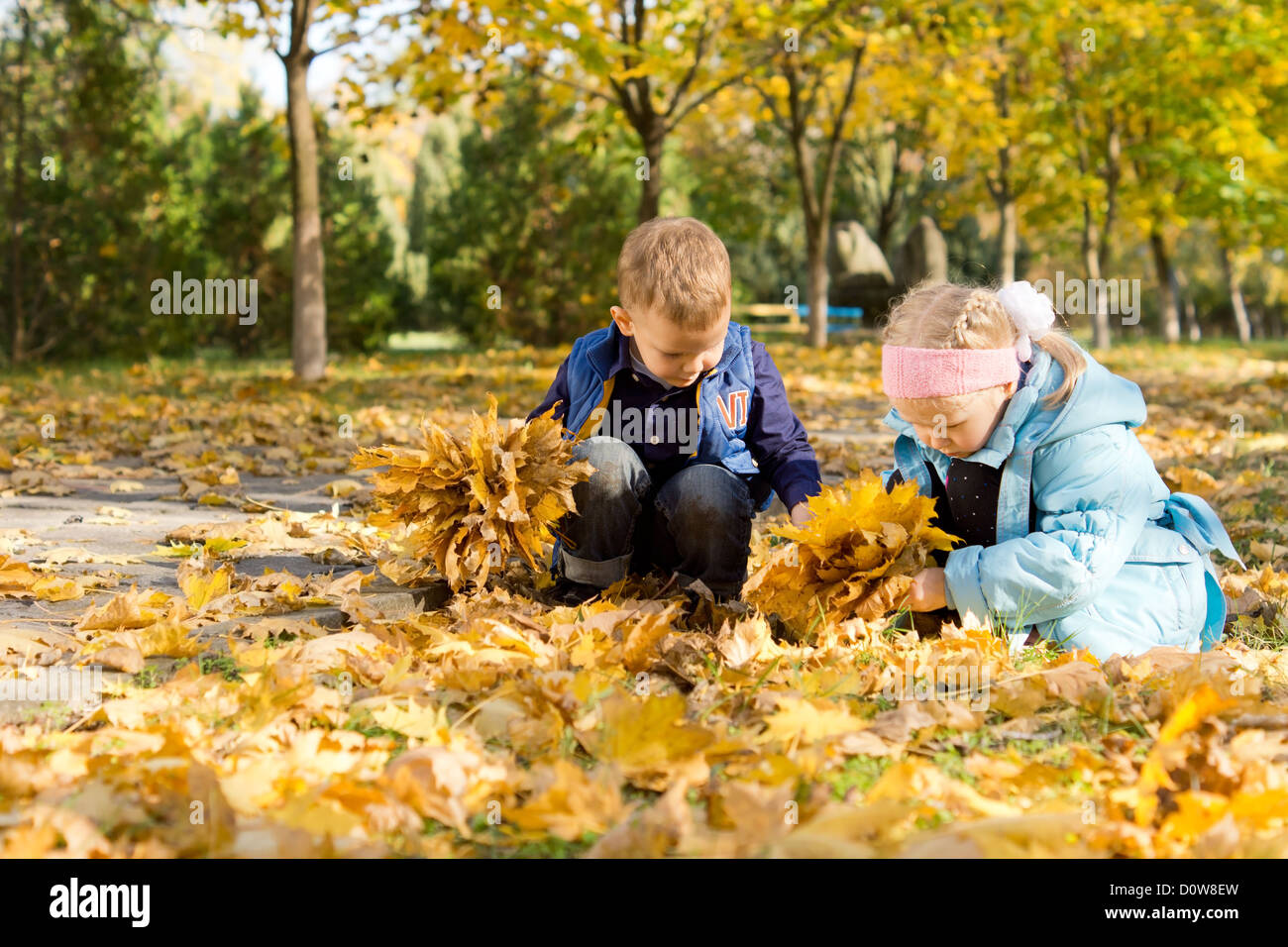 Он любит играть листьями. Осенью собирали листья в парке. Дети собирают листья. Осенний парк ребенок с листьями. Дети собирают листву в парке.