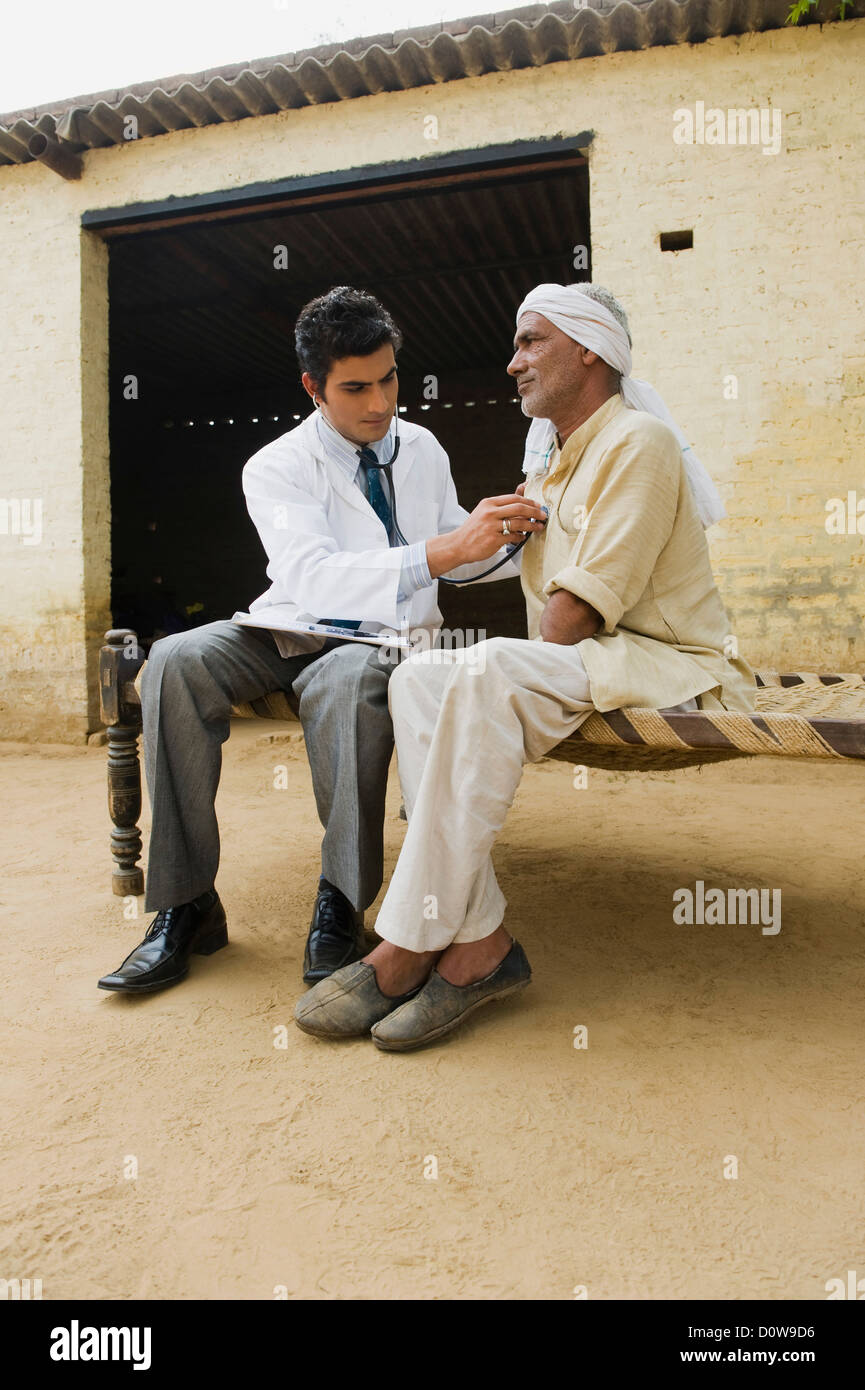 Doctor examining a farmer with a stethoscope, Hasanpur, Haryana, India